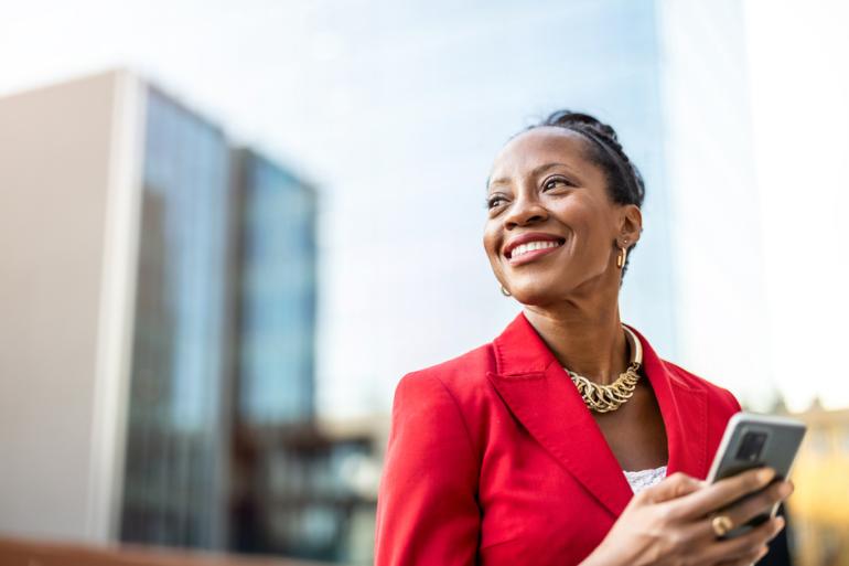 Mujer sonriendo con un celular en la mano